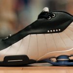 Image of a black and white athletic sneaker with an elaborate cushioning system in its heel.