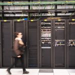 A visitor walks past a computer bay at the PA10 data center, operated by Equinix Inc., in Paris, France.